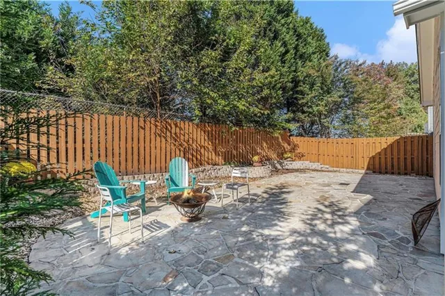 a view of backyard with wooden fence and large trees