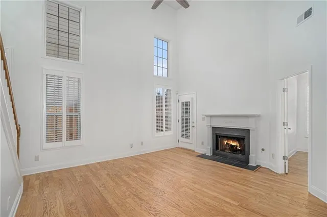 an empty room with windows and fireplace