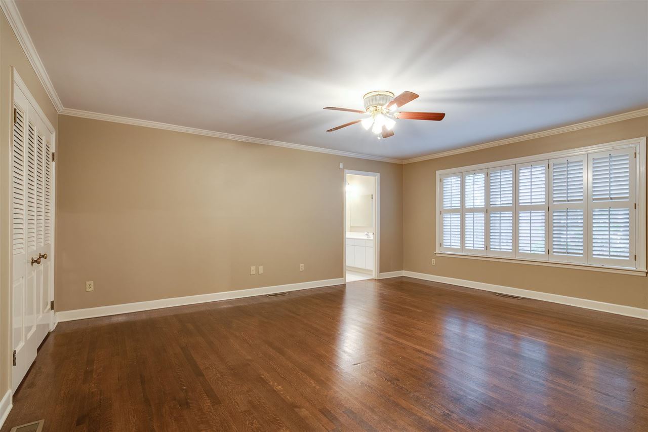 4515 Aldersgate Road, Unit 2 Memphis, TN 38117 - Photo 21 of 25 a view of an empty room with chandelier fan and wooden floor