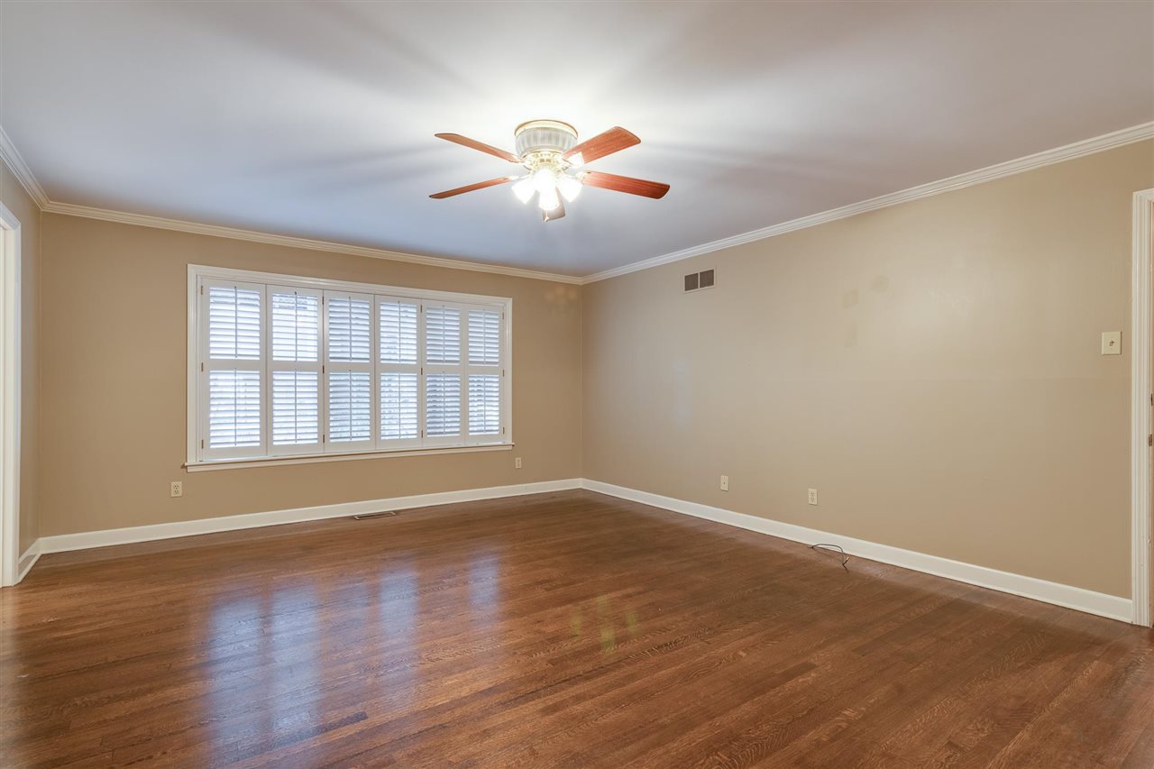 4515 Aldersgate Road, Unit 2 Memphis, TN 38117 - Photo 22 of 25 a view of an empty room with chandelier fan and wooden floor