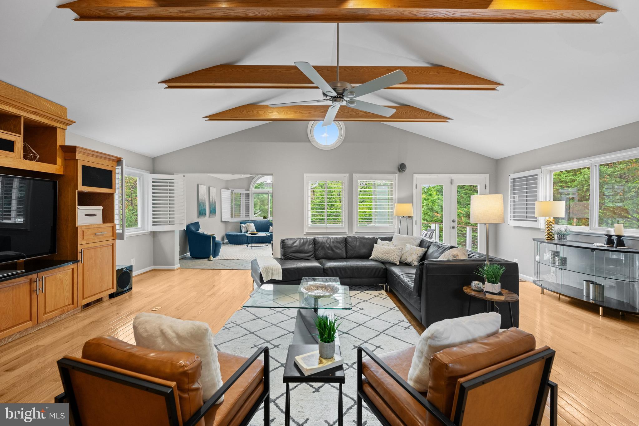 a living room with furniture a flat screen tv and a large window
