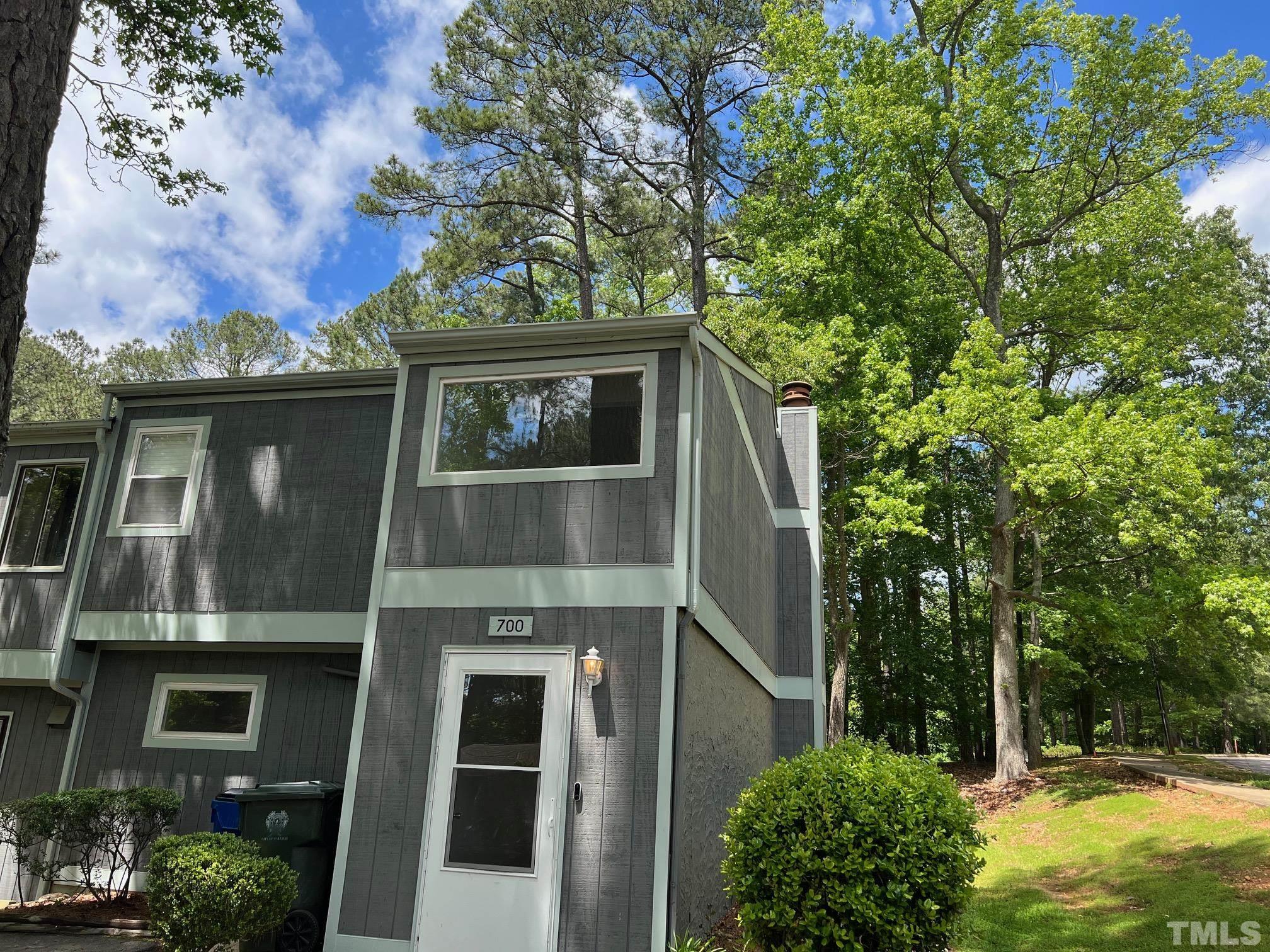 a view of a brick house with large windows and a tree