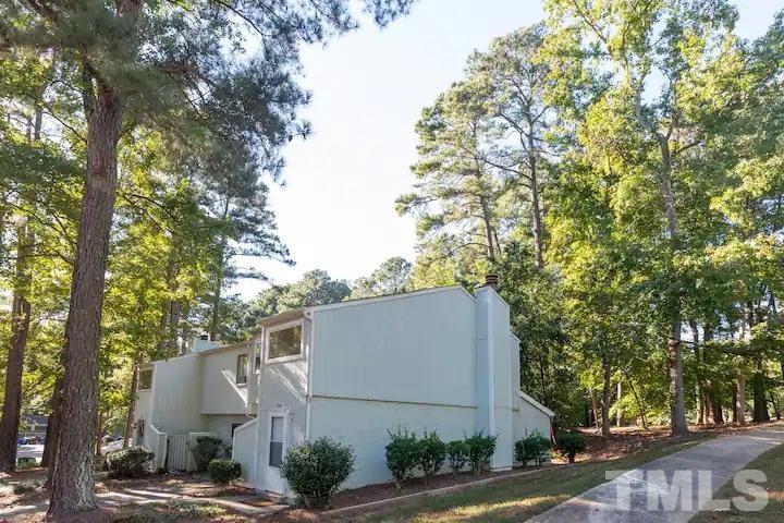 700 Godwin Court Raleigh, NC 27606 - Photo 2 of 20 a view of a white house with large tree and wooden fence