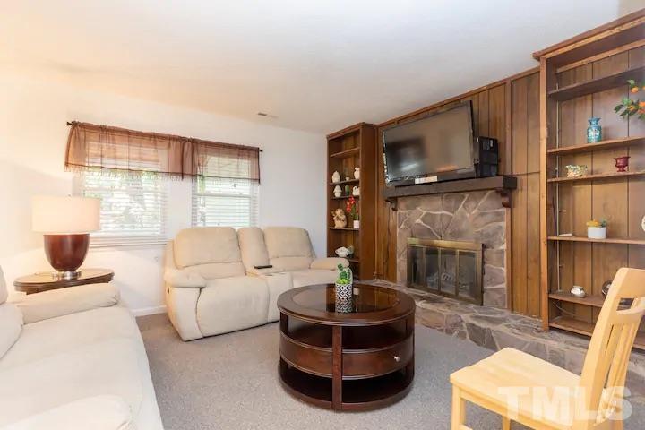 700 Godwin Court Raleigh, NC 27606 - Photo 5 of 20 a living room with furniture a fireplace and a flat screen tv