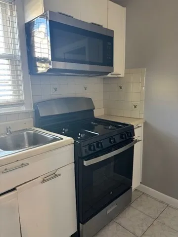 a stove top oven sitting inside of a kitchen