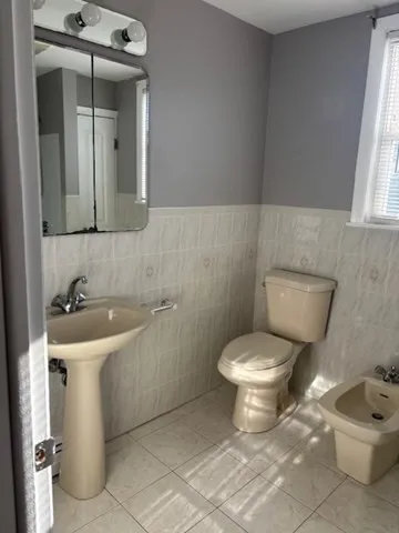 a bathroom with a toilet sink and mirror