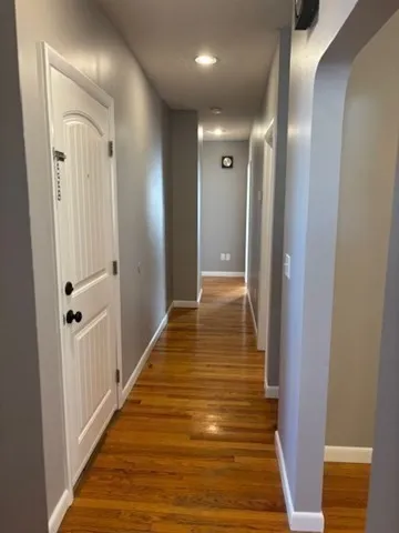 a view of a hallway with wooden floor