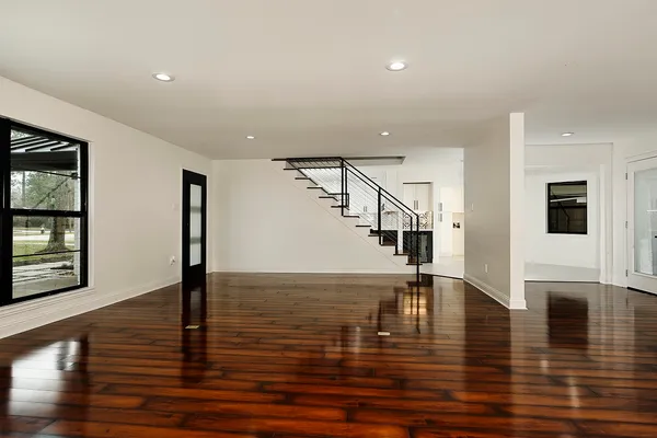 a view of empty room with wooden floor and floor to ceiling window