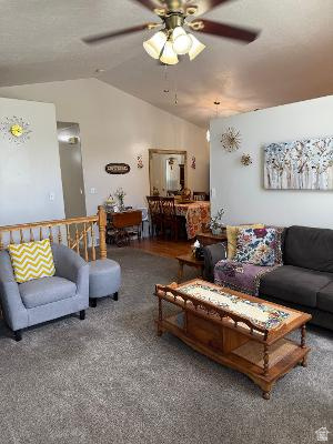 641 East Greystone Way Tooele, UT 84074 - Photo 3 of 30 Vaulted ceilings accentuate the living area, featuring textured carpeting and a ceiling fan with integrated lighting