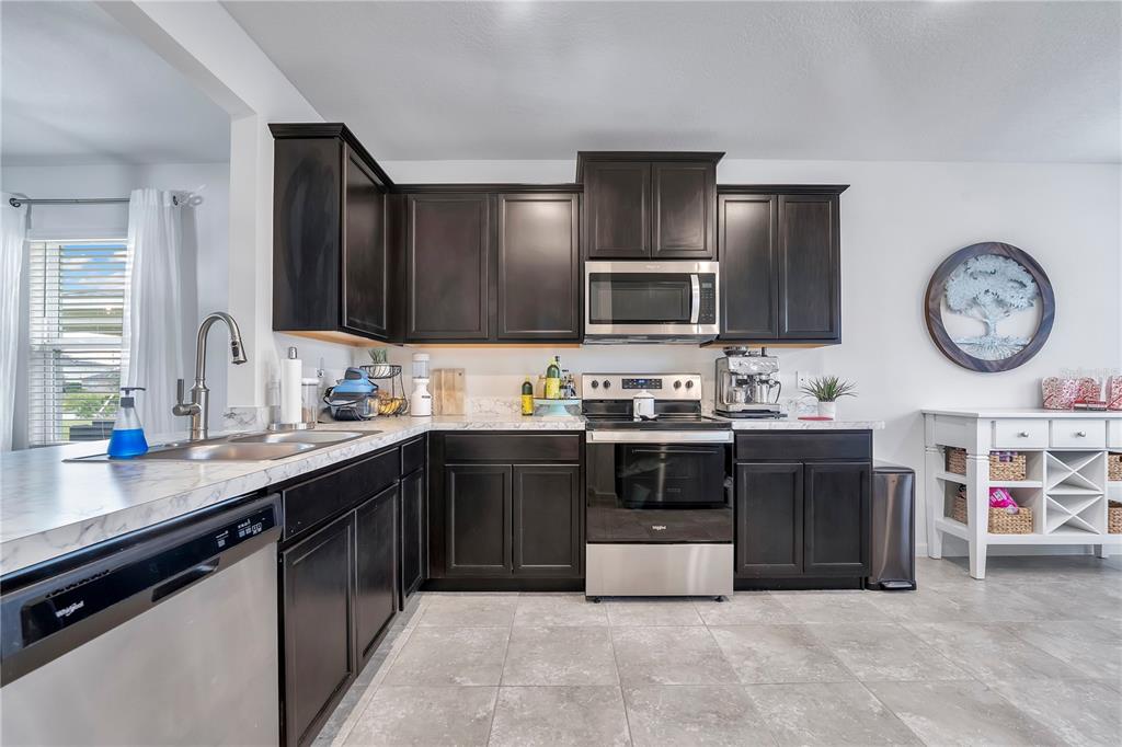 9201 Potomac Drive Fort Pierce, FL 34945 - Photo 7 of 24 a kitchen with stainless steel appliances a stove a sink a chimney and a refrigerator