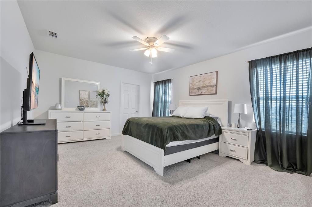 9201 Potomac Drive Fort Pierce, FL 34945 - Photo 10 of 24 a spacious bedroom with a large bed and a chandelier