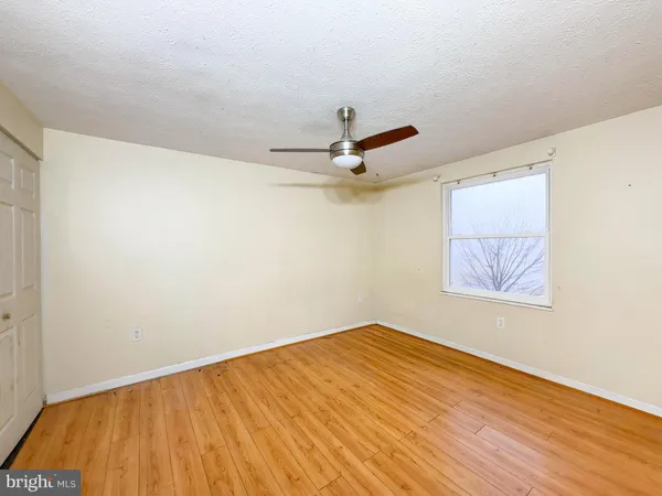 a view of a room with wooden floor and a ceiling fan