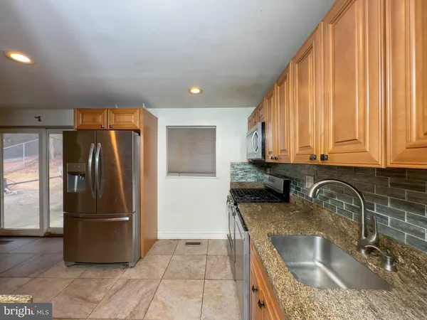 a kitchen with stainless steel appliances granite countertop a refrigerator and a sink
