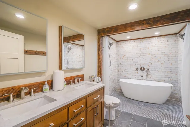 a spacious bathroom with a double vanity sink mirror and bathtub