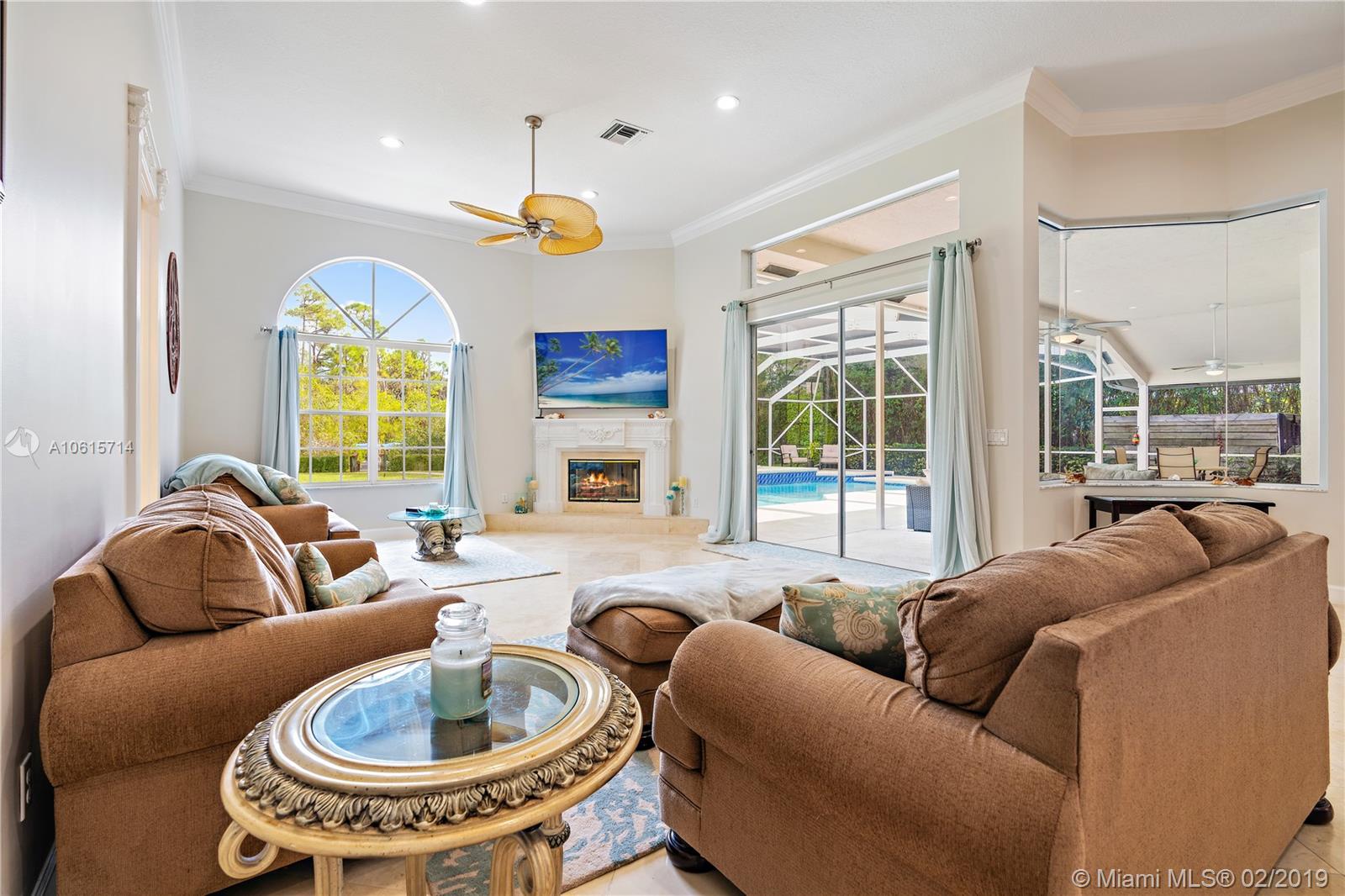 18897 Southeast Loxahatchee River Road Jupiter, FL 33458 - Photo 11 of 48 Family room with marble floors, 12ft volume ceilings with crown molding. Lots of natural light from windows and slider doors. Wood burning fireplace with marble hearth.