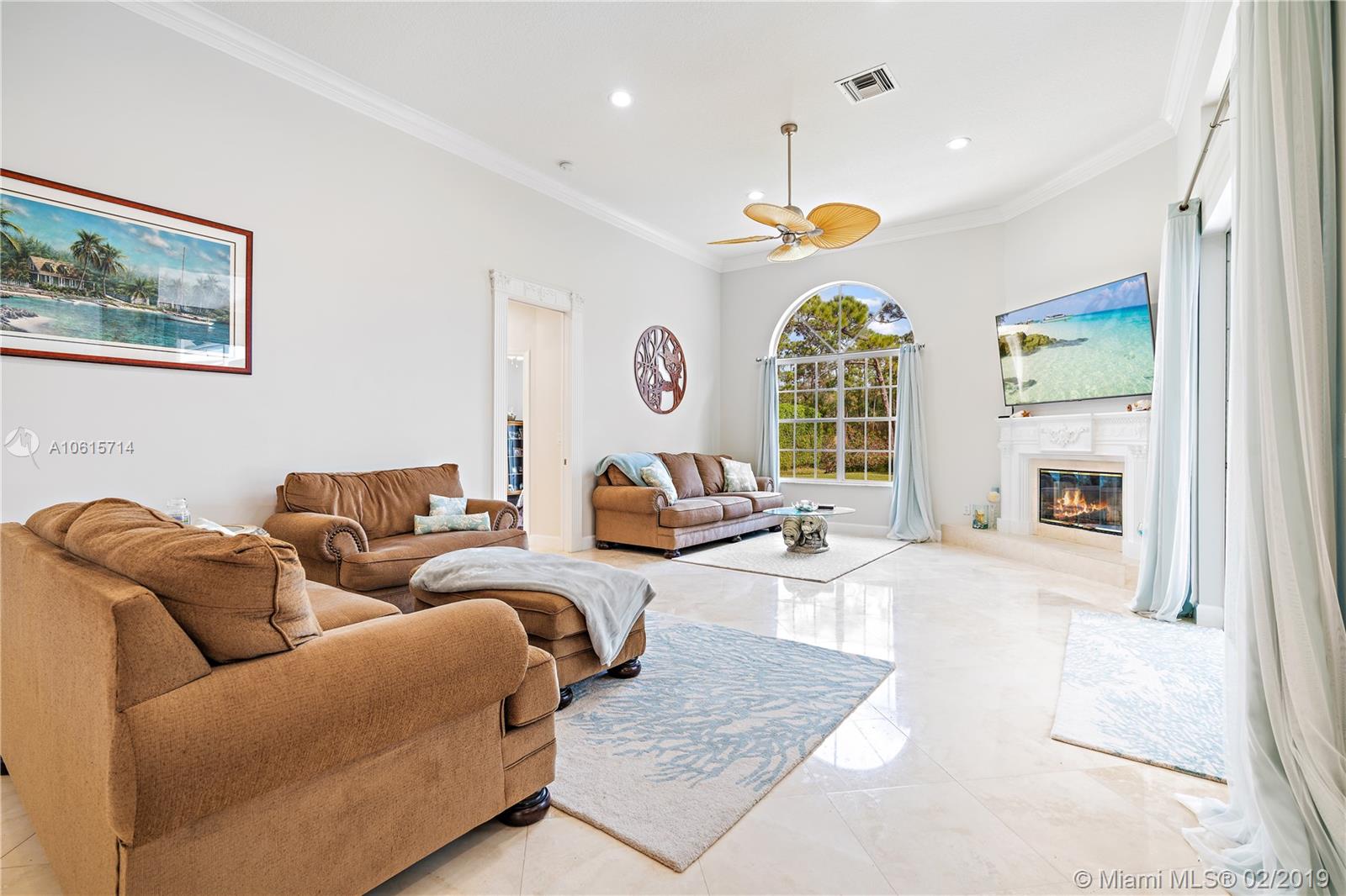 18897 Southeast Loxahatchee River Road Jupiter, FL 33458 - Photo 12 of 48 Family room with marble floors, 12ft volume ceilings with crown molding. Lots of natural light from windows and slider doors. Wood burning fireplace with marble hearth.