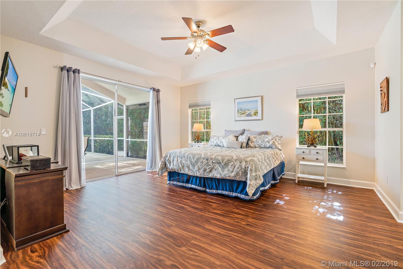 18897 Southeast Loxahatchee River Road Jupiter, FL 33458 - Photo 13 of 48 Master bedroom with 12ft ceilings. Vinyl plank cork backed flooring. Has two walk in closets with built in cabinetry and large linen closet. Loads of storage!