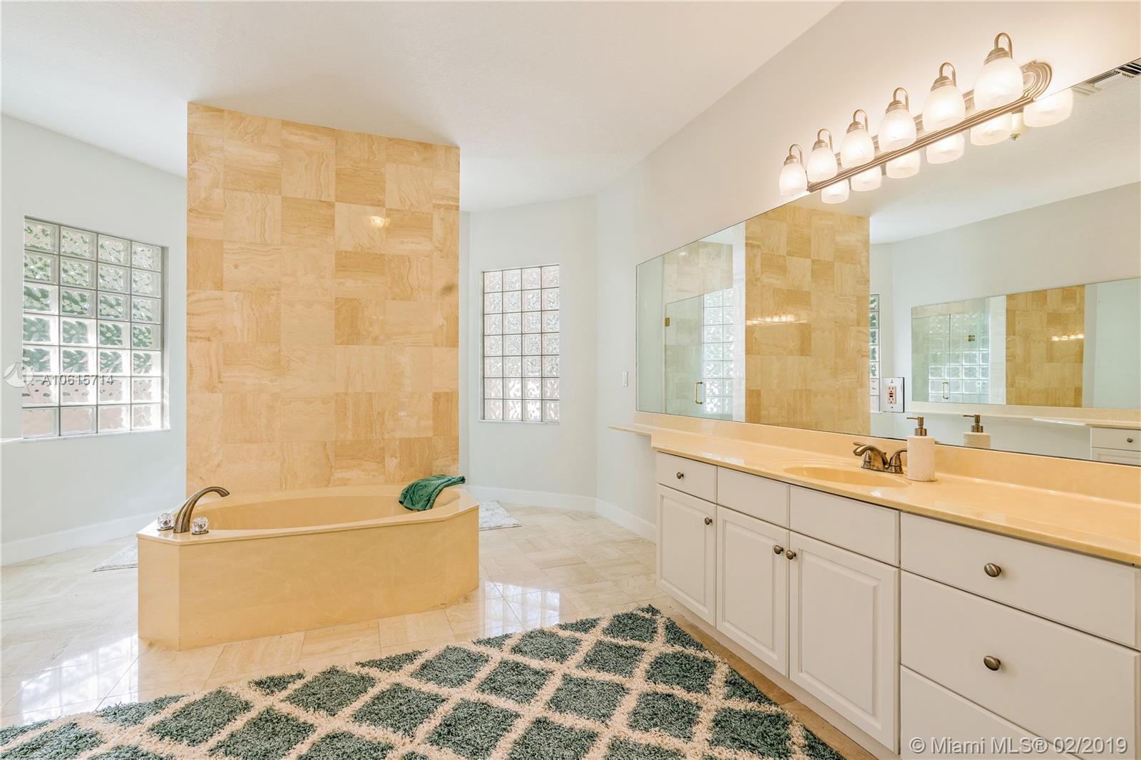 18897 Southeast Loxahatchee River Road Jupiter, FL 33458 - Photo 15 of 48 Master bathroom with marble floors dual sinks and vanities. Dual access shower behind the roman tub tile wall.