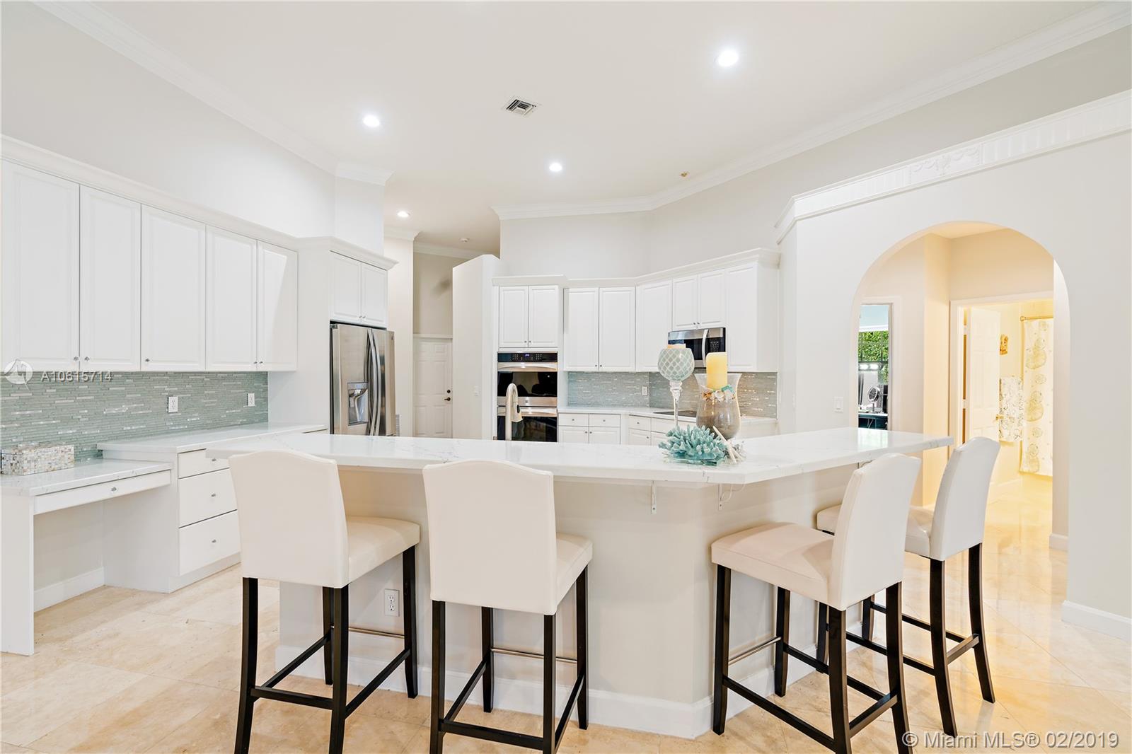 18897 Southeast Loxahatchee River Road Jupiter, FL 33458 - Photo 7 of 48 New kitchen with quartz counter tops, breakfast bar, stainless steel appliances and marble floors. 12ft volume ceilings with crown molding.