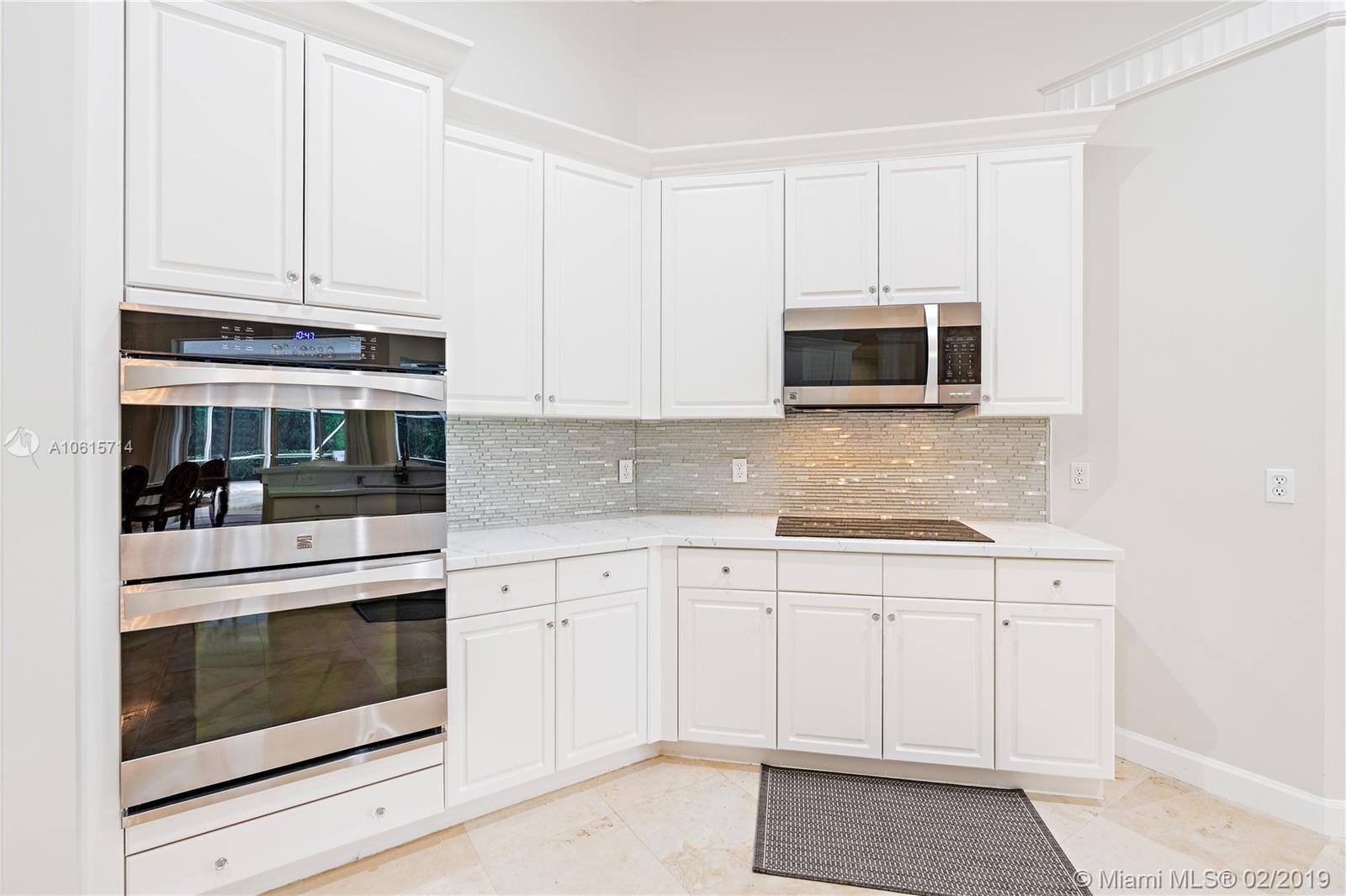 18897 Southeast Loxahatchee River Road Jupiter, FL 33458 - Photo 8 of 48 Stainless steel appliances -convection ovens, cooktop, microwave with quartz counter tops, crown molding finishes.