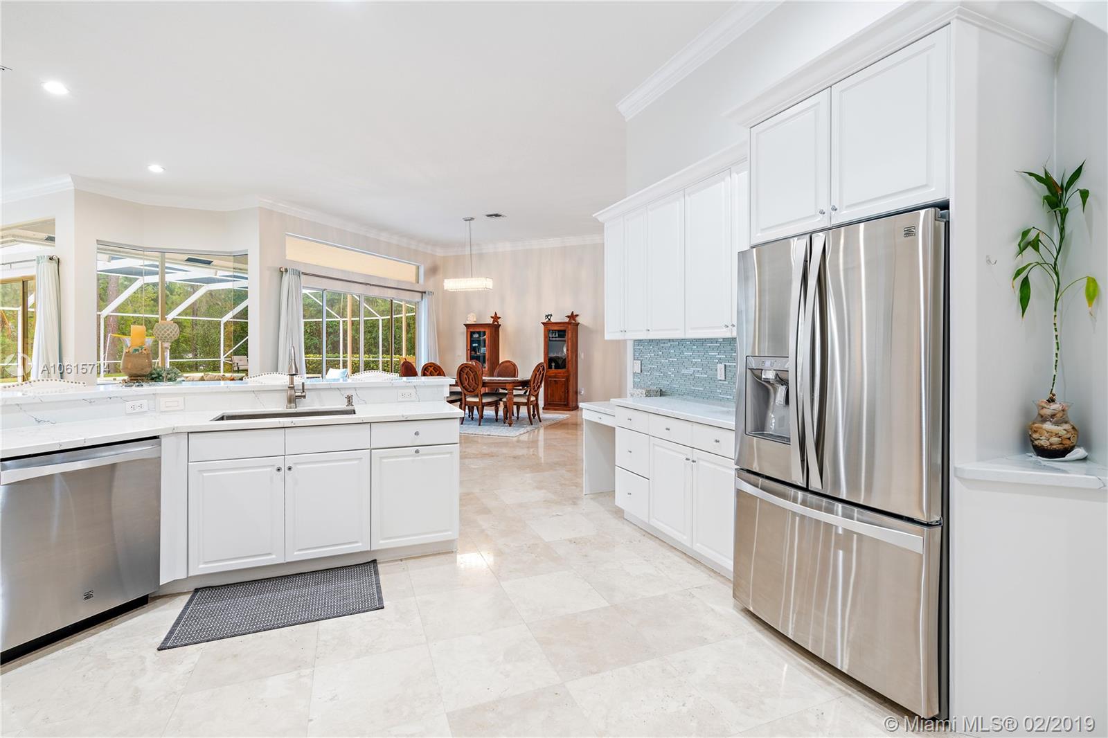 18897 Southeast Loxahatchee River Road Jupiter, FL 33458 - Photo 9 of 48 Kitchen view to great room. Marble floors, 12ft volume ceilings with crown moldings.