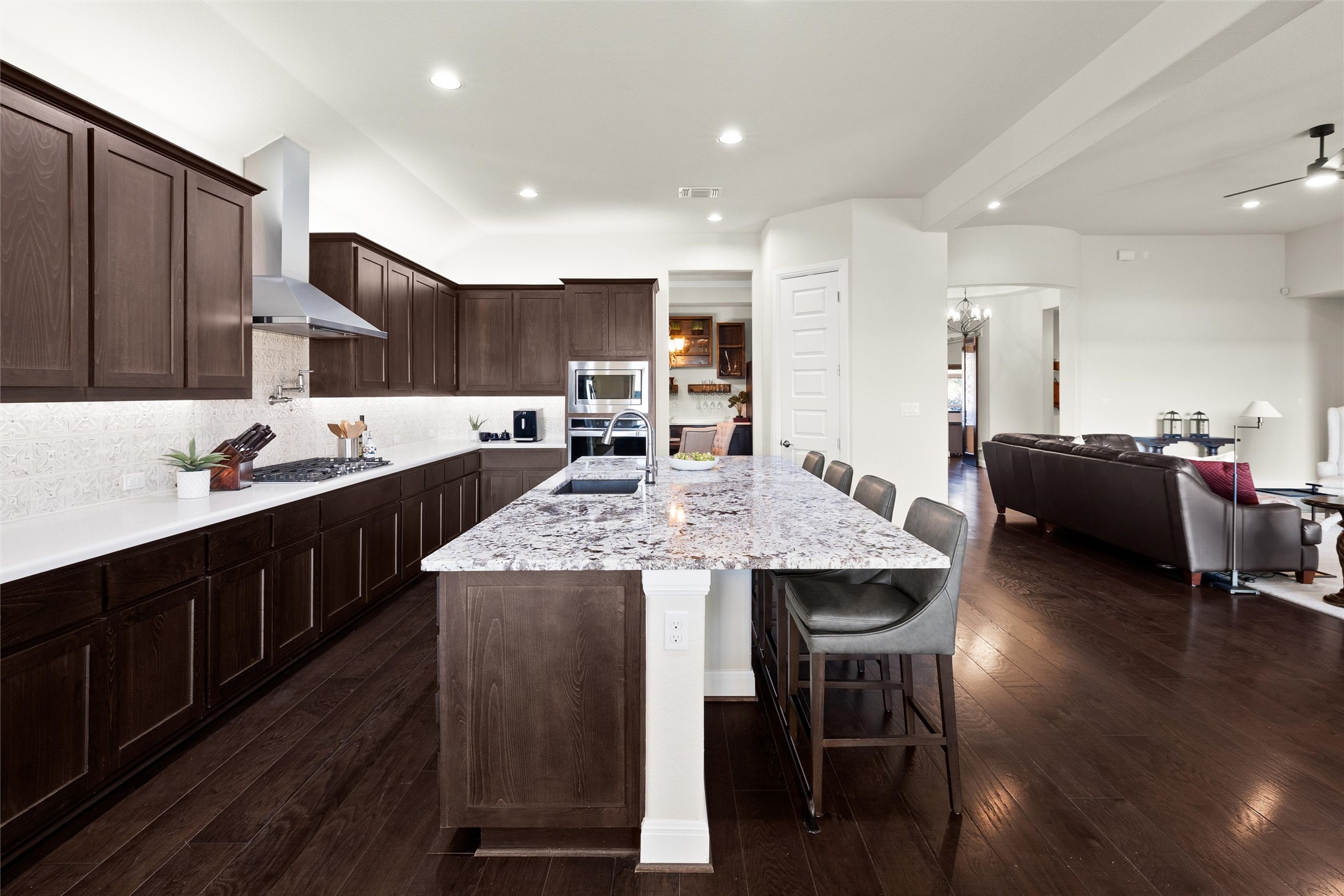 479 Crosswater Lane Dripping Springs, TX 78620 - Photo 12 of 40 a kitchen with kitchen island granite countertop wooden floors and wooden cabinets