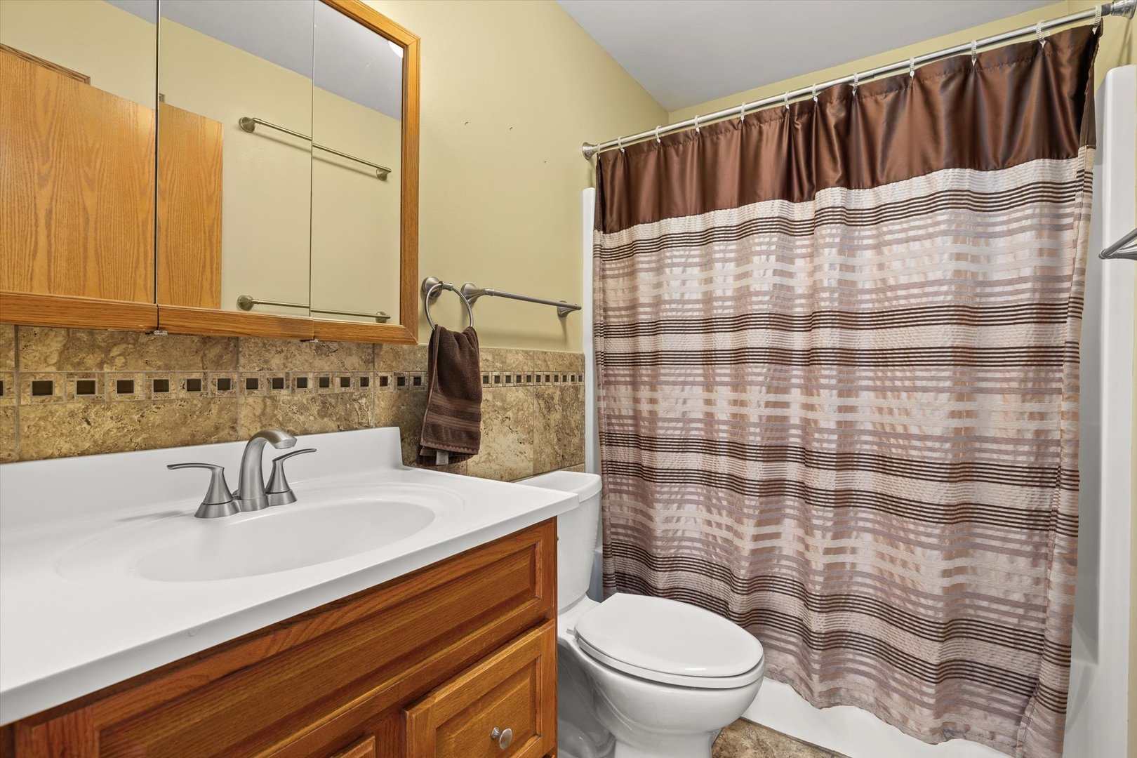 794 Farragut Avenue Romeoville, IL 60446 - Photo 18 of 23 a bathroom with a sink a toilet and shower curtain