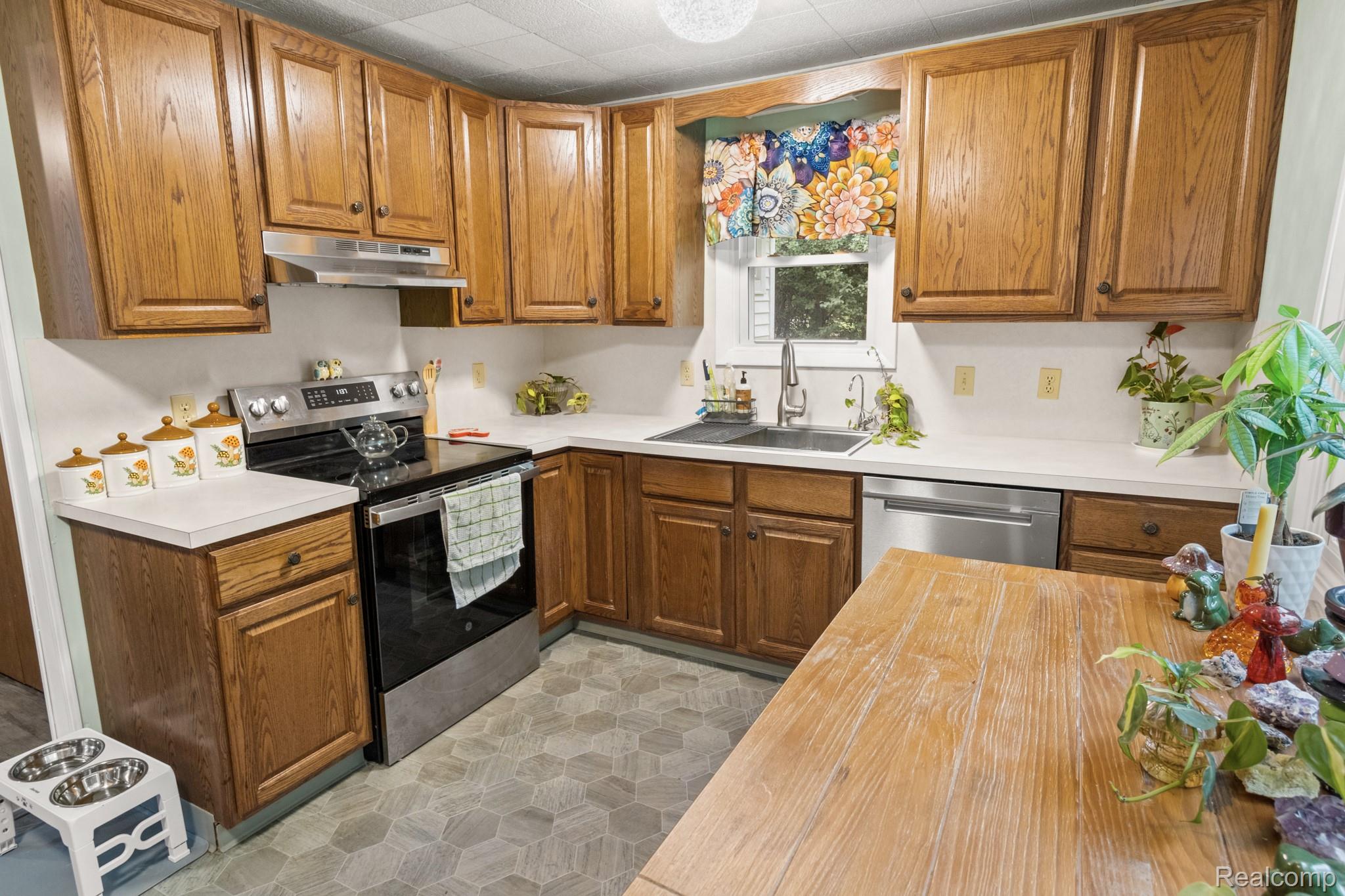 7330 Embury Road Grand Blanc, MI 48439 - Photo 12 of 29 Kitchen featuring wood cabinetry, white countertops, a stainless steel range, and a stainless steel dishwasher