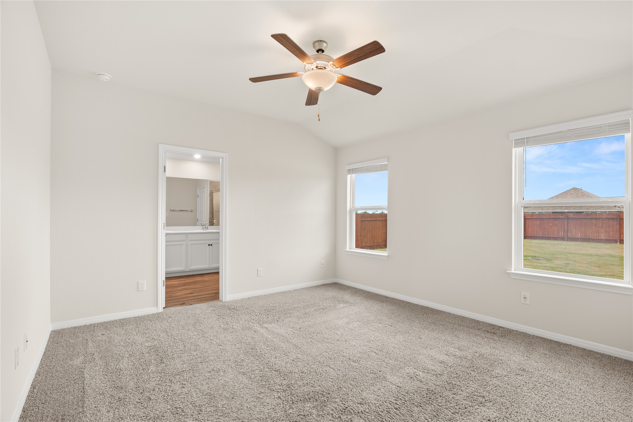 105 Saviano Road Hutto, TX 78634 - Photo 8 of 22 Primary Bedroom: A quiet retreat with plush carpet and ample natural light, offering a private en suite bath.