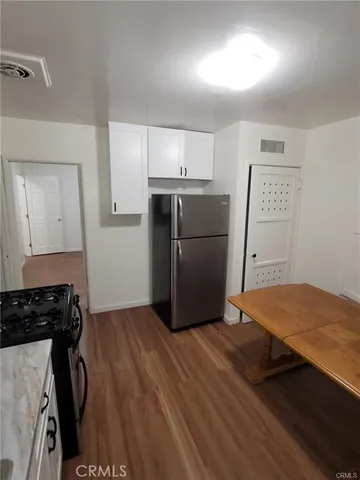 a kitchen with a refrigerator and a stove top oven