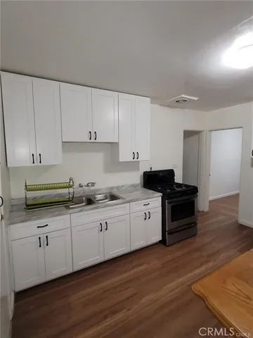 a kitchen with granite countertop a sink and cabinets