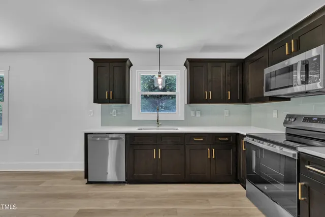 a kitchen with stainless steel appliances granite countertop a sink and a stove top oven