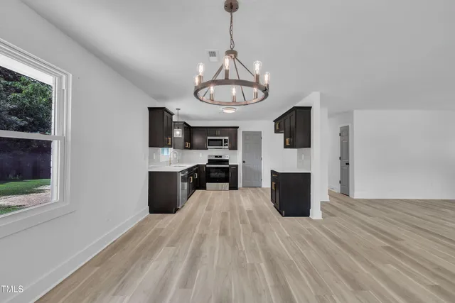 a view of a kitchen with wooden floor and a window