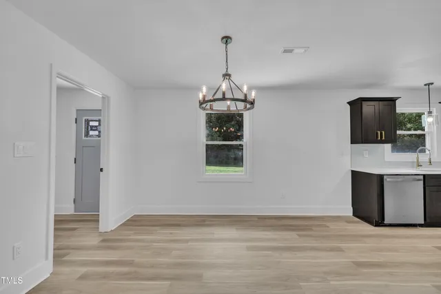 a view of a room with wooden floor and a chandelier