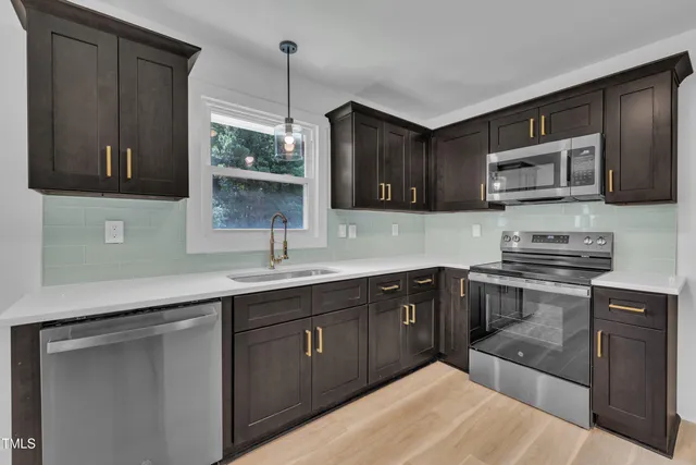 a kitchen with stainless steel appliances granite countertop a sink stove and microwave