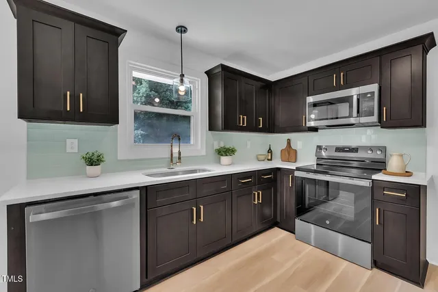 a kitchen with stainless steel appliances granite countertop a sink stove and microwave