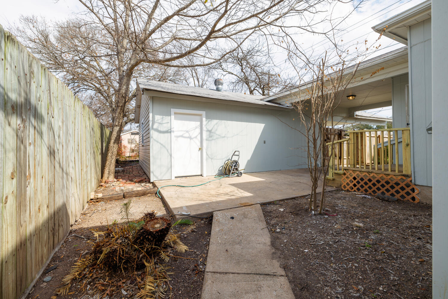 1400 Ruth Avenue Austin, TX 78757 - Photo 25 of 29 A concrete patio and walkway sit enclosed within a tall privacy fence.