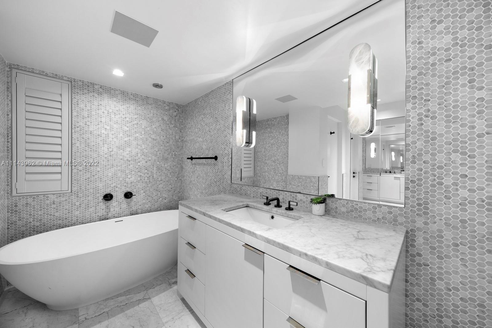 554 Lakeview Drive Miami Beach, FL 33140 - Photo 19 of 20 a bathroom with a granite countertop sink mirror and bathtub