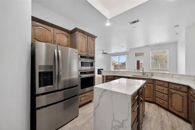 a kitchen with granite countertop a refrigerator and a sink