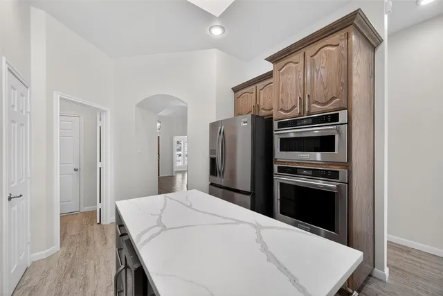 a kitchen with stainless steel appliances a stove a refrigerator and a refrigerator