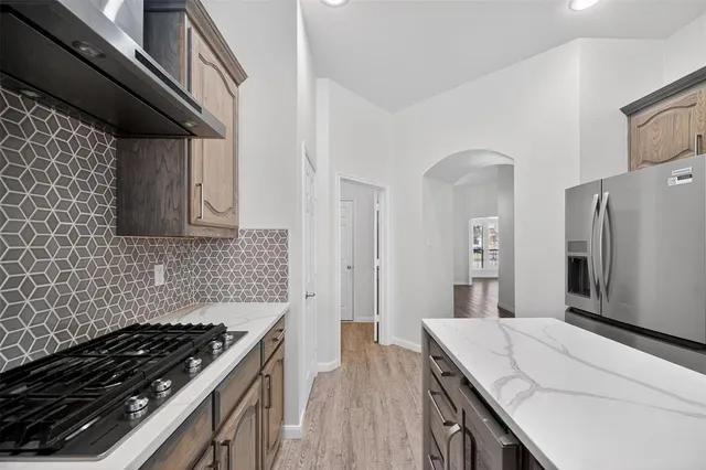 a kitchen with granite countertop a stove and a refrigerator