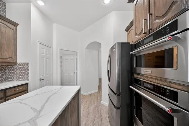a kitchen with stainless steel appliances a refrigerator and a stove top oven