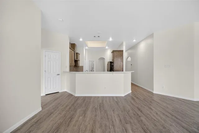 a view of a kitchen with wooden floor and a refrigerator
