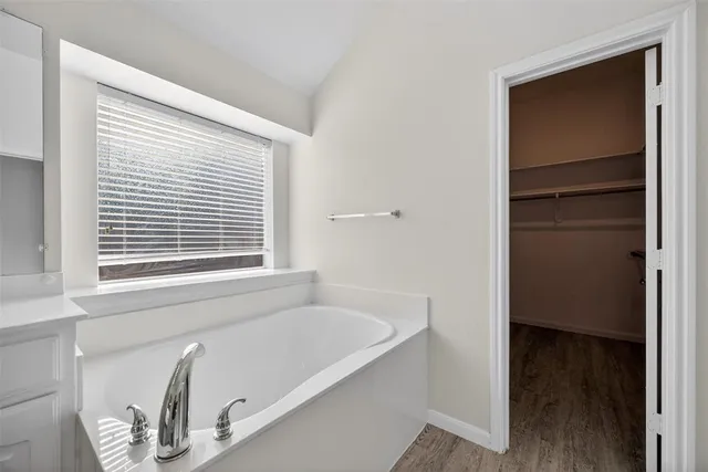 a bathroom with a tub and a window