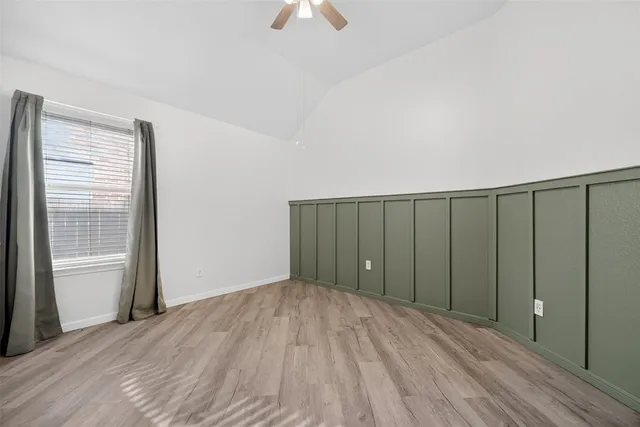 a view of wooden floor and a chandelier fan in a room
