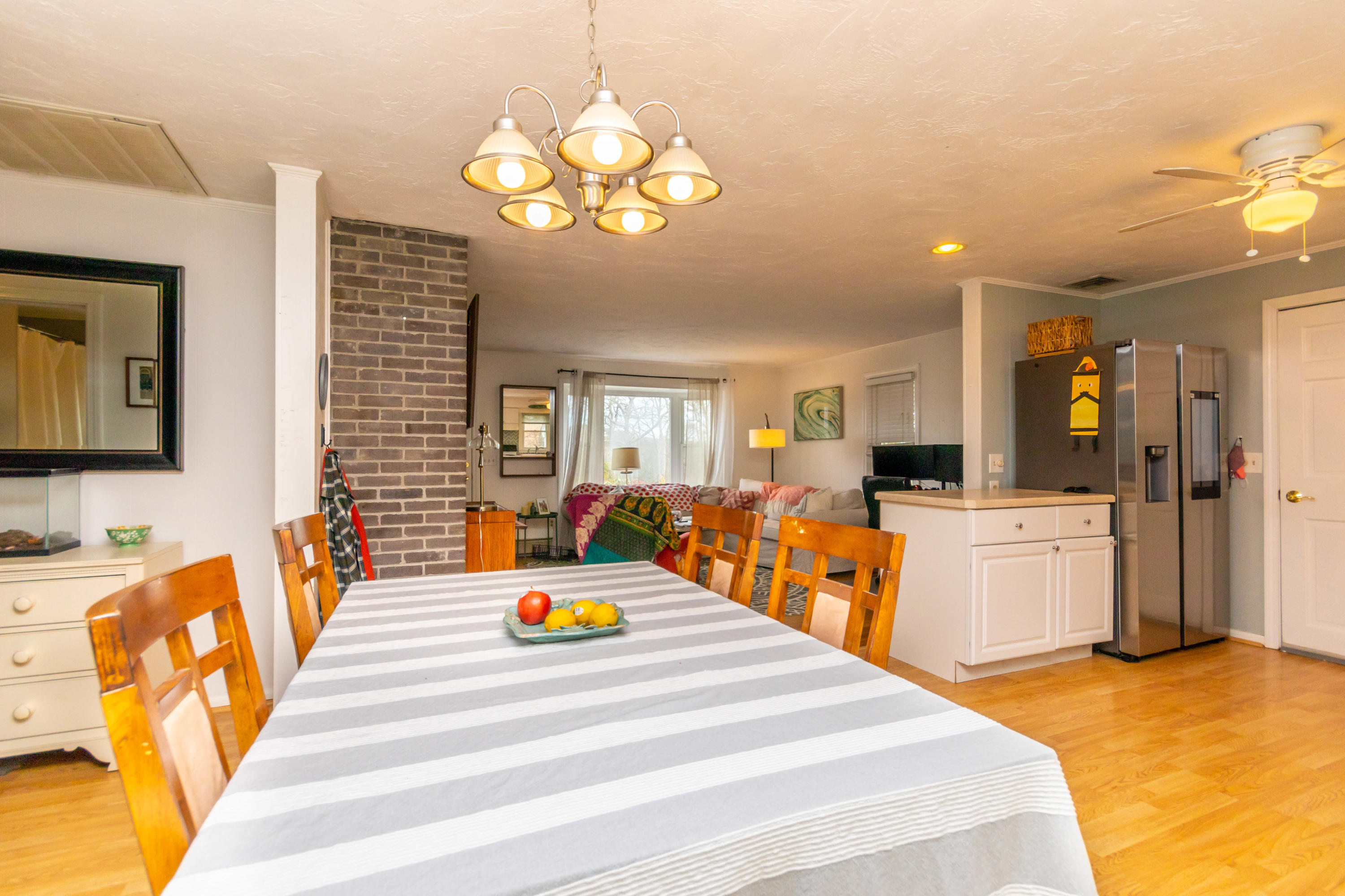 2 Long Boat Road Bourne, MA 02532 - Photo 11 of 30 a large room with lots of white furniture a chandelier a flat tv screen and a chandelier