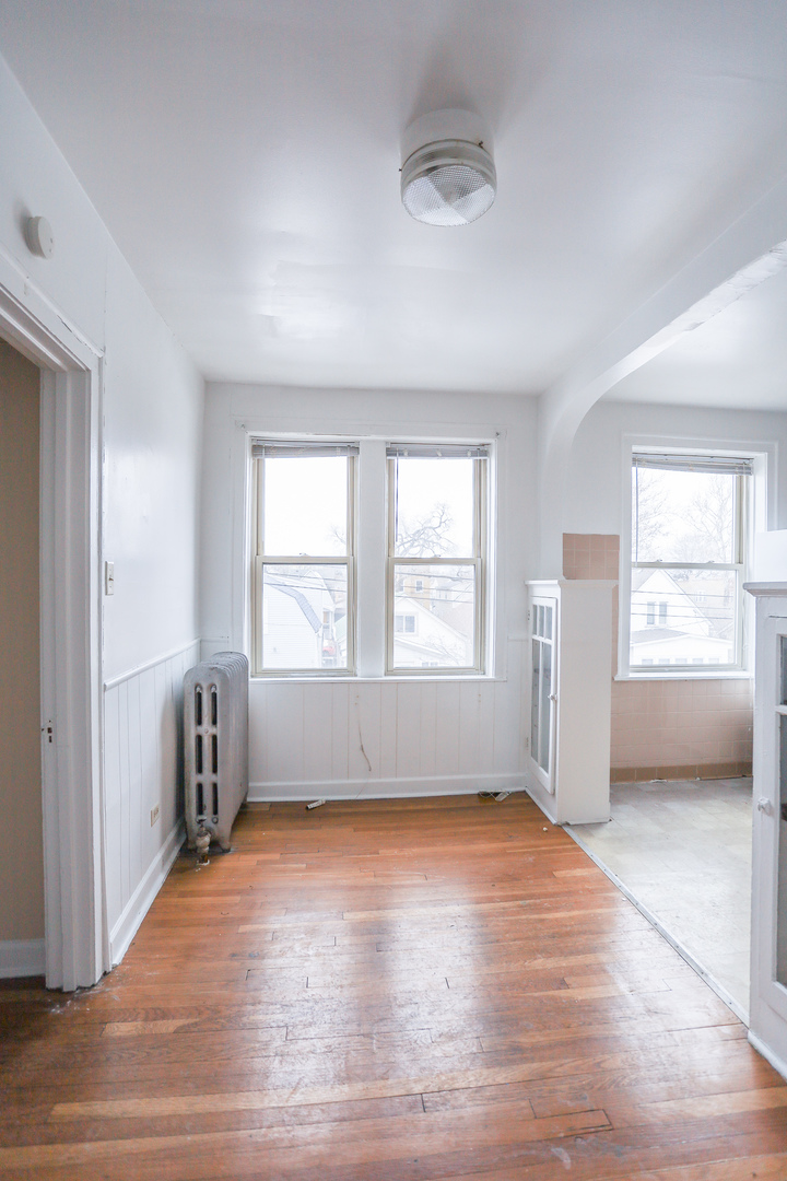4724 West Addison Street, Unit 3A Chicago, IL 60641 - Photo 3 of 11 an empty room with wooden floor and windows