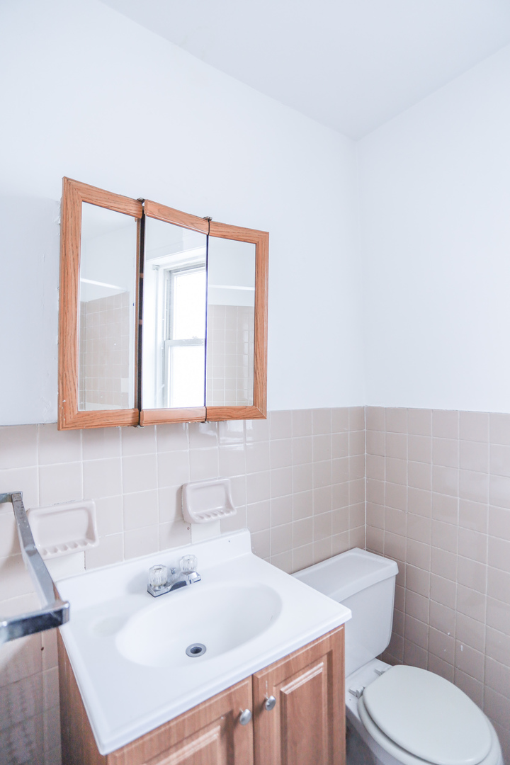 4724 West Addison Street, Unit 3A Chicago, IL 60641 - Photo 7 of 11 a bathroom with a sink a toilet and mirror