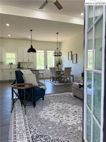 a living room with furniture a rug and kitchen view