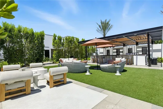 a view of a patio with table and chairs under an umbrella with a fire pit